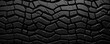 Texture of thick and chunky tire rubber, with a rugged pattern resembling tire tracks. This type of rubber is ideal for offroad adventures and can handle rough and uneven terrain.