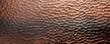 Closeup of hammered steel A unique texture with a handcrafted feel, created by repeated indentations and hammering. The steel has a warm bronze or copper color with a rugged surface that