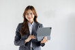 © David - Asian businesswoman hoding digital tablet standing in office isolated on white background, Smiling woman executive manager, Feeling happiness.