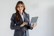 © David - Asian businesswoman hoding digital tablet standing in office isolated on white background, Smiling woman executive manager, Feeling happiness.
