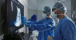 © N F/peopleimages.com - Surgery, x ray and a team of doctors in the hospital for an operation or procedure to remove a tumor. Healthcare, medical teamwork and a surgeon looking at a screen with a medicine professional