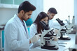Lab technicians checking on microscope at laboratory