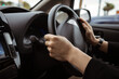 © Studio-M - Driving a car photo background. Steering wheel and hands of a driver, city car interior