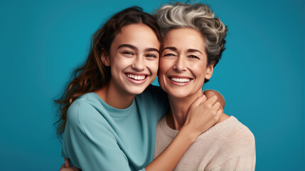 Sticker - Happy mother and daughter smiling and hugging against the blue background.