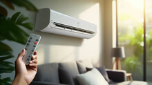 Hand Holding Remote Control Aimed At The Air Conditioner. Woman Turning On Air Conditioner With Remote Control.