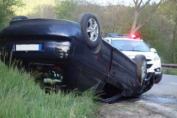 Wall Mural - Car accident. An overturned car lying upside down on the street after an accident. The car crashed on the road and overturned. Real event. 