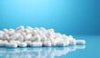 White pills scattered on a blue background.