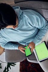 Poster - Phone, green screen and a man playing games on a sofa in the living room of his home from above. Tablet, gaming and young gamer using a display or screen with tracking markers for entertainment