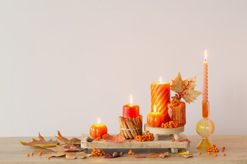 Wall Mural - autumn decor with burning candles on wooden shelf