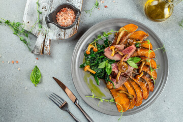 Wall Mural - Spicy veal steak roasted served with baked potato, fresh greens on a light background top view. place for text