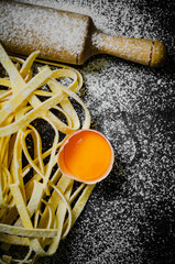 Wall Mural - Homemade pasta tagliatelle. On black table.