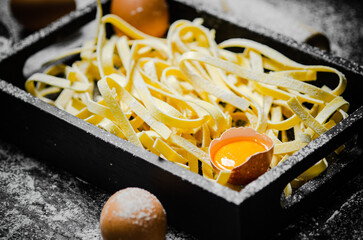 Wall Mural - Homemade pasta tagliatelle. On black table.