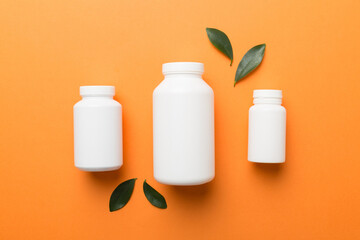 supplement pills with medicine bottle health care and medical top view. Vitamin tablets. Top view mockup bottle for pills and vitamins with green leaves, natural organic bio supplement, copy space