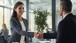 Happy Smiling mid aged business woman manager handshaking greeting client in office. Smiling female executive making successful deal with partner shaking hand at work standing at meeting table