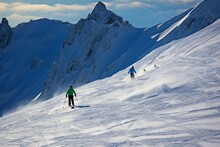 Alpine Skiers Embrace The Stunning Snowy Backdrop Of The Mountain Range