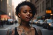 © liliyabatyrova - Horizontal portrait of a beautiful African woman looking away with a tattoo on her body wearing a black top, gold jewelry, earrings, necklace on a city street.
