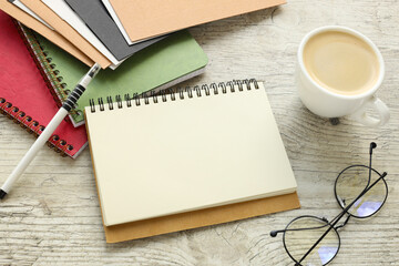Wall Mural - a cup of coffee and glasses near a blank notepad with a pen or pencil on an office on a wooden table. notepad on office folder