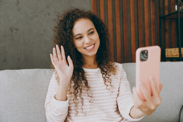 Sticker - Young woman wear casual clothes sits on grey sofa couch do selfie shot on mobile cell phone post photo on social network stay at home hotel flat rest relax spend free spare time in living room indoor.