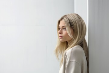 Wall Mural - young woman thinking with pensive expression against wall background. 