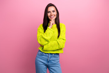 Poster - Photo of good mood lovely girl with long hairstyle dressed yellow sweatshirt hand on chin smiling isolated on pink color background