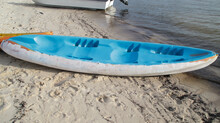 Blue Plastic Canoe Boat Pulled Ashore At The Beach