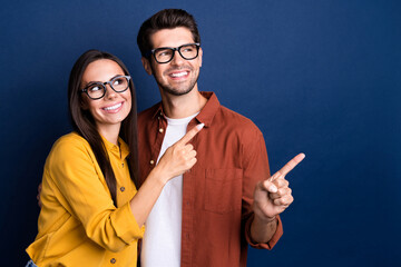 Wall Mural - Portrait of successful positive partners beaming smile look direct finger empty space information isolated on blue color background