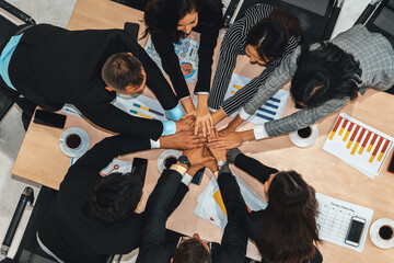 Wall Mural - Happy business people celebrate teamwork success together with joy at office table shot from top view . Young businessman and businesswoman workers express cheerful victory show unity support . Jivy