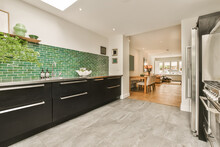 Kitchen With Black Cabinets And Green Tile Wall