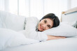 © NewSaetiew - Young Woman Waking Up with Happiness in Cozy Bedroom at Home. Beautiful Girl Smiling and Relaxing in Bed after Waking Up.