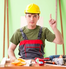 Wall Mural - Young man carpenter working in workshop