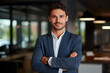 © Prasanth - Smiling confident young businessman looking at camera standing in office. Elegant stylish corporate leader successful ceo executive manager.