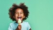 Joyful little girl, with curly hair, eating an ice cream on a pastel green background. Generative AI