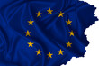 © Alexprint - European Union flag blowing in the wind with torn edges on silk texture