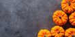 Orange pumpkins seen from above on gray background