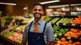 Fototapeta  - Portrait of an attractive smiling Indian young man shop worker standing in a supermarket Young male food store assistant vegetable and fruit retailer selective focus