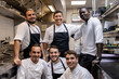 © Martin - Multi ethnic cooking team posing for a team photo in the kitchen at work