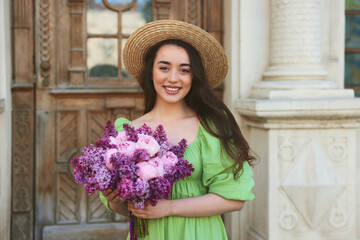 Canvas Print - Beautiful woman with bouquet of spring flowers near building outdoors