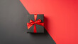 Top view photo of black gift box with red ribbon on two color background