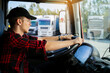 © phoenix021 - Young Caucasian truck driver with black sports cap with hands on the wheel, closeup