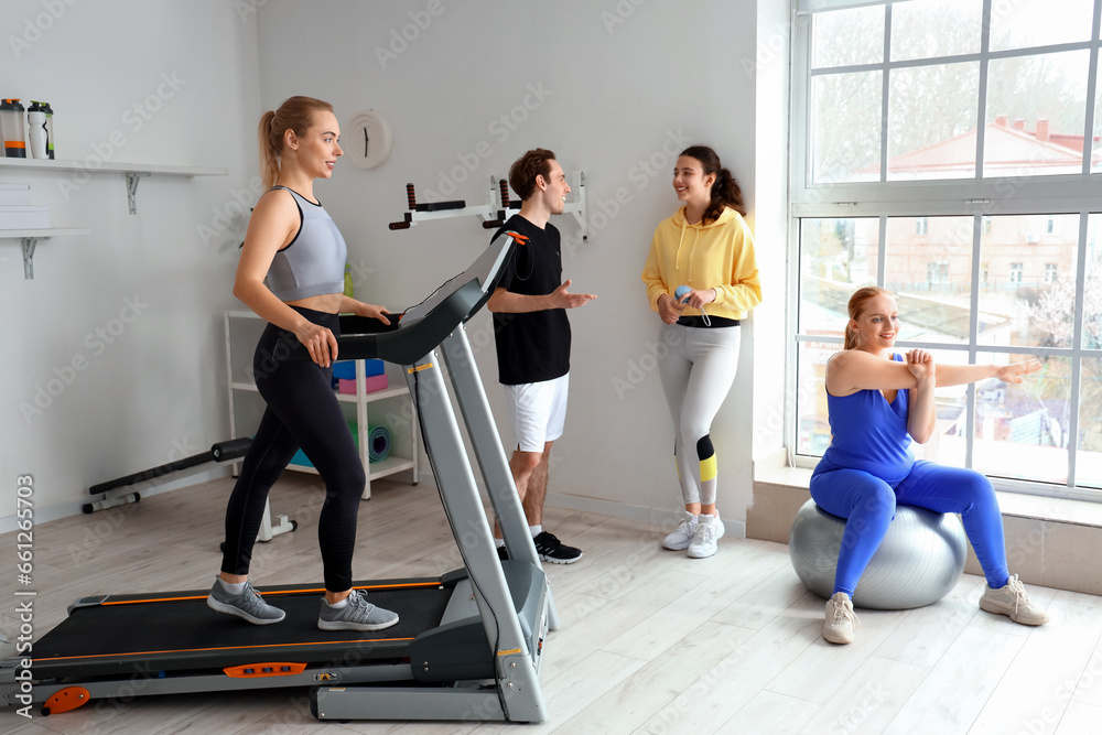 Group of sporty young people training in gym