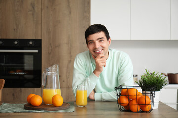 Sticker - Young man with oranges and juice in kitchen