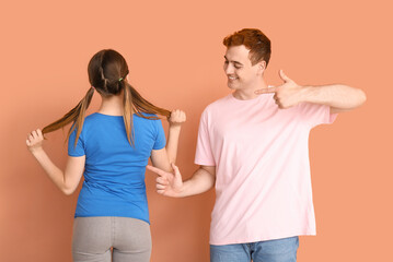 Wall Mural - Young couple in t-shirts on beige background