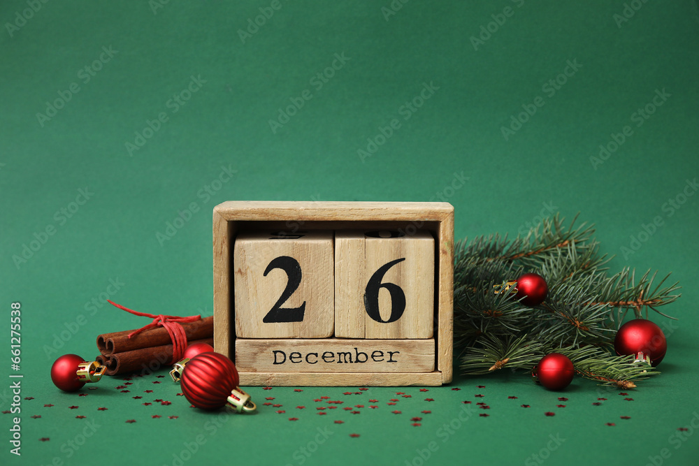 Composition with wooden cube calendar, Christmas decorations and  fir branches on green background