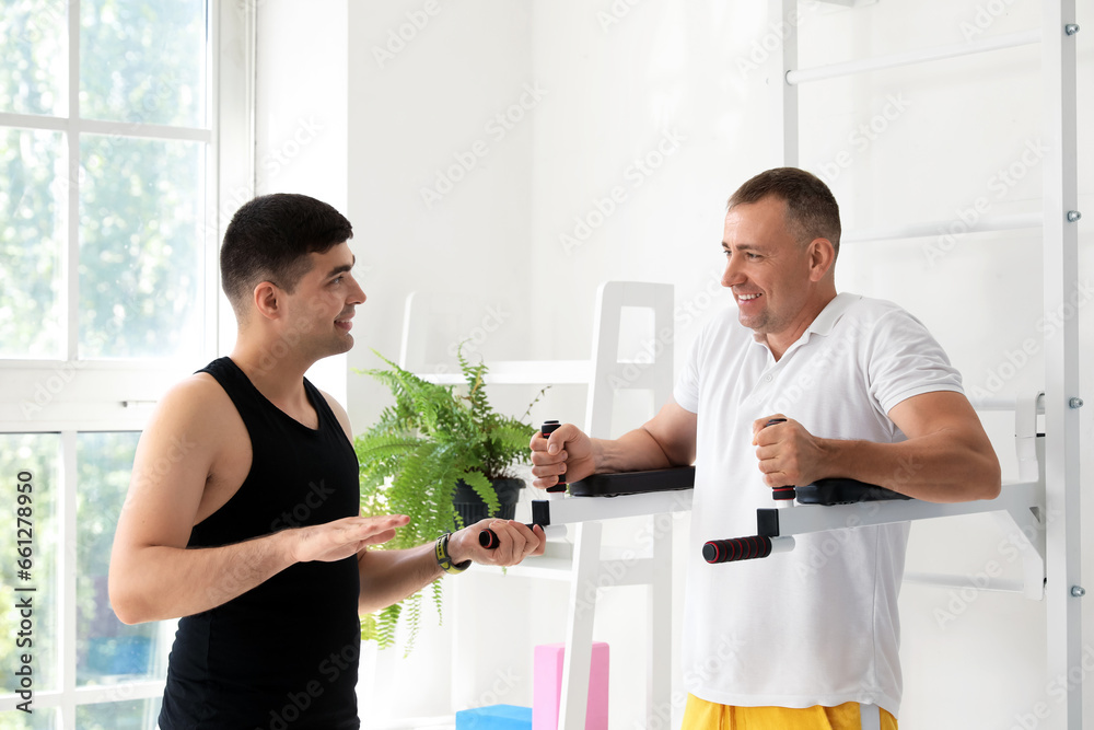 Mature man training with therapist in rehabilitation center
