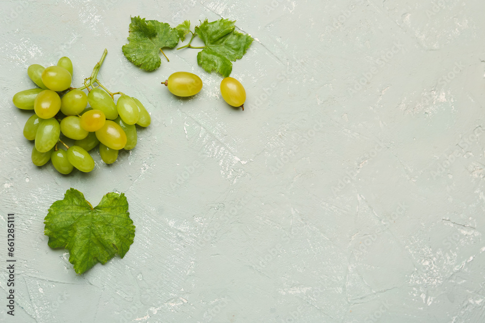 Raceme of juicy white grapes on grey background