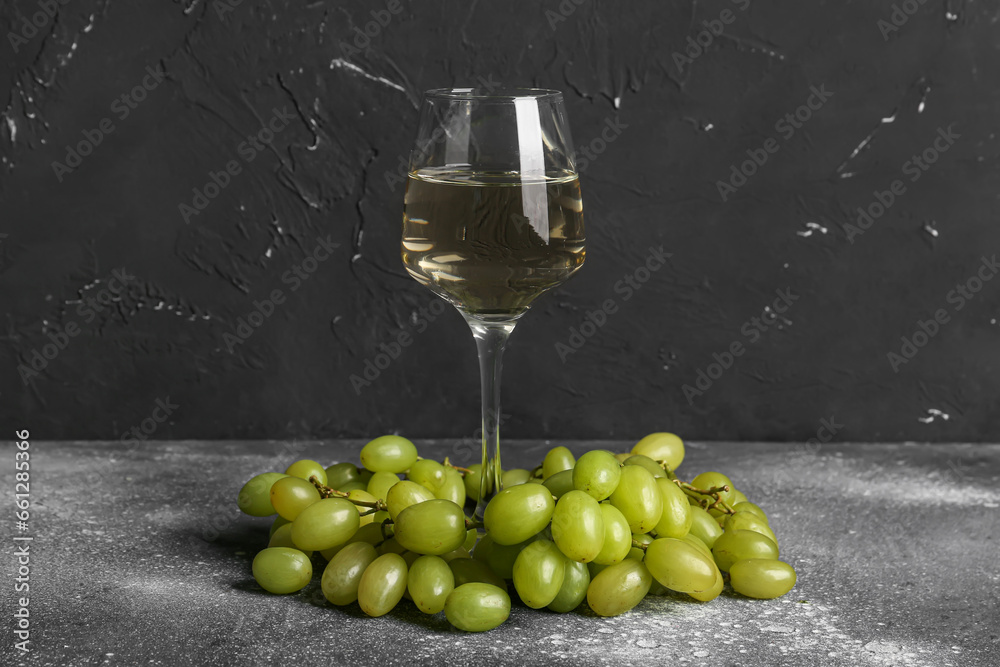 Grapes and glass of wine on grey background