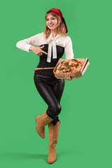 Poster - Young woman dressed for Halloween as pirate pointing at tasty pizza on green background