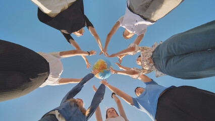friends hold and toss a geographic globe in their hands. the concept of keeping the world safe.