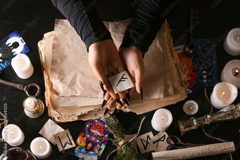 Witch with rune on dark table, top view