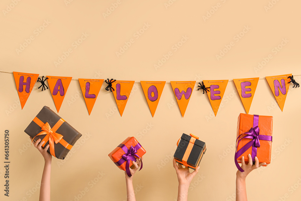 Women with Halloween gifts and flags on beige background
